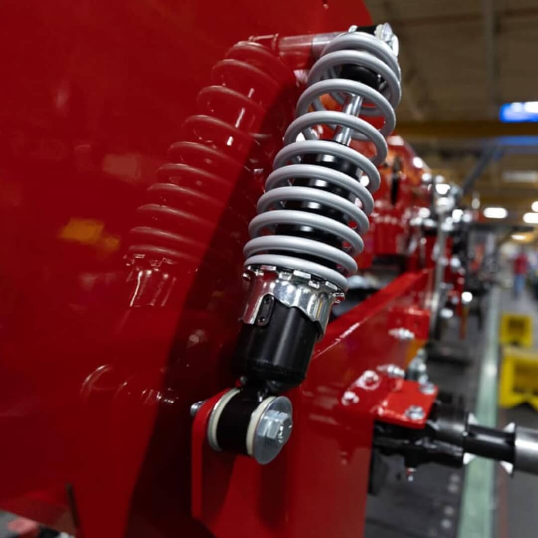 Close-up of a red motorcycle with suspension system in a showroom setting