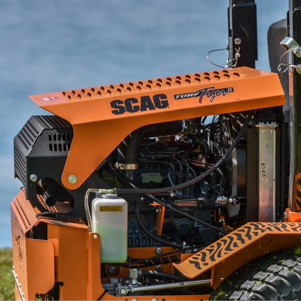 Close-up of an orange SCAG lawn mower with a blurred water background
