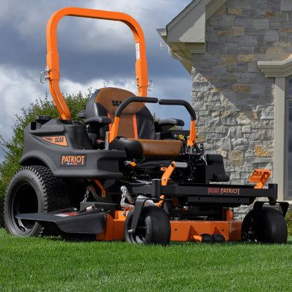 Scag Patriot zero-turn lawn mower on a grassy area with a stone building in the background