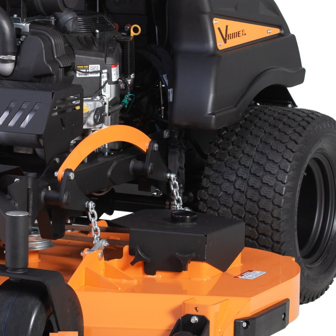Close side view of a ride on mower showing tire tread, cutting deck and engine.